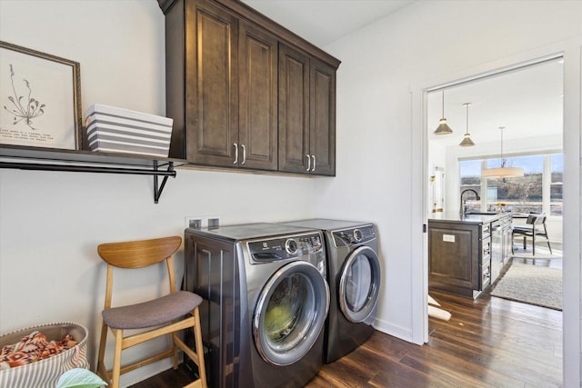 clothes washing area featuring cabinets, dark hardwood / wood-style floors, sink, and washer and clothes dryer