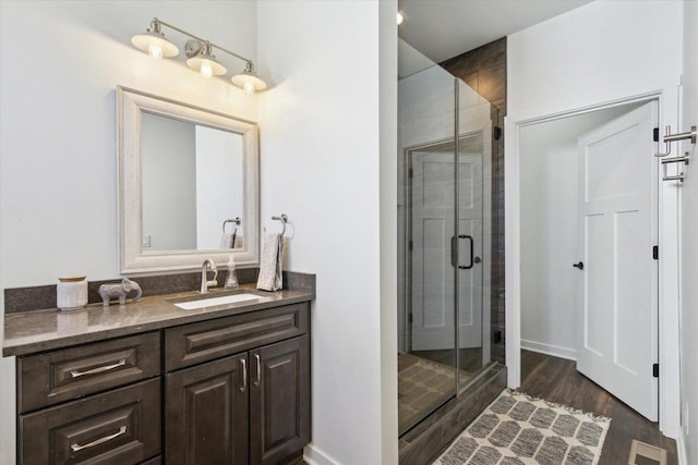 bathroom with vanity, hardwood / wood-style flooring, and walk in shower