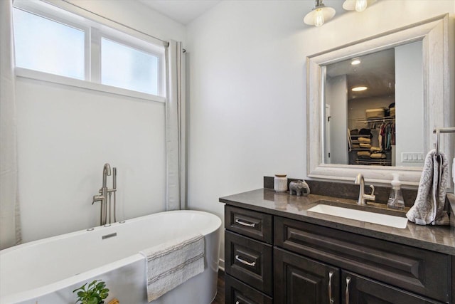 bathroom featuring a tub to relax in and vanity