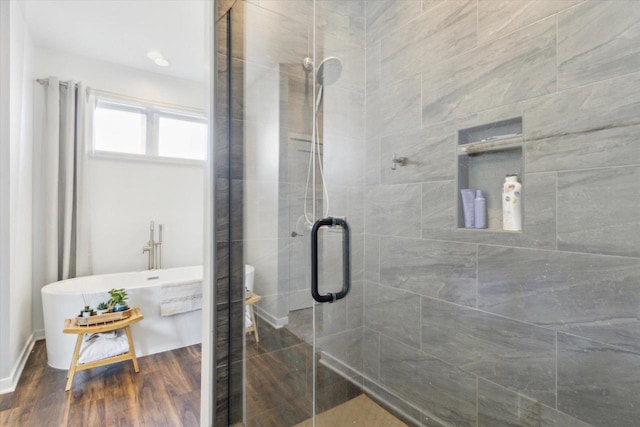 bathroom with wood-type flooring and plus walk in shower