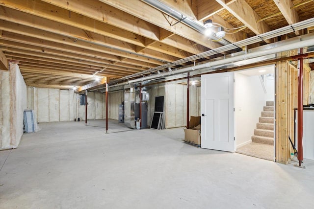 basement with electric water heater and heating unit