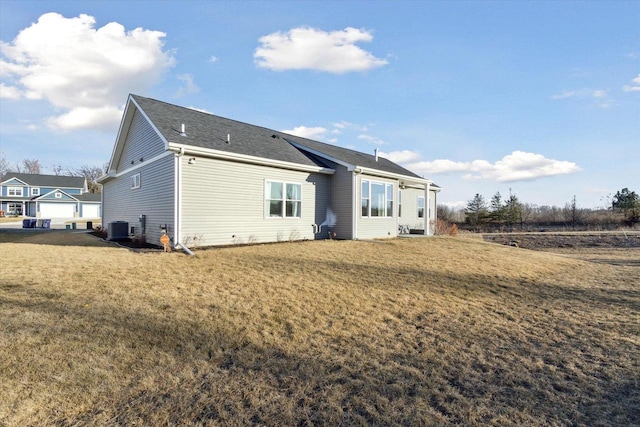 rear view of house featuring a yard and central AC