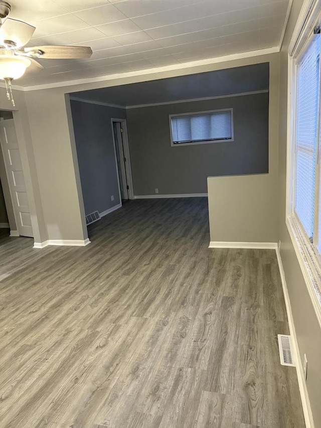 empty room with ceiling fan, hardwood / wood-style floors, and crown molding