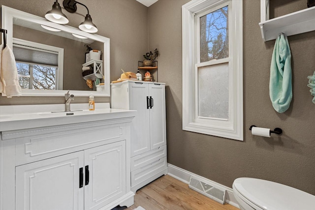 bathroom with hardwood / wood-style flooring, vanity, and toilet