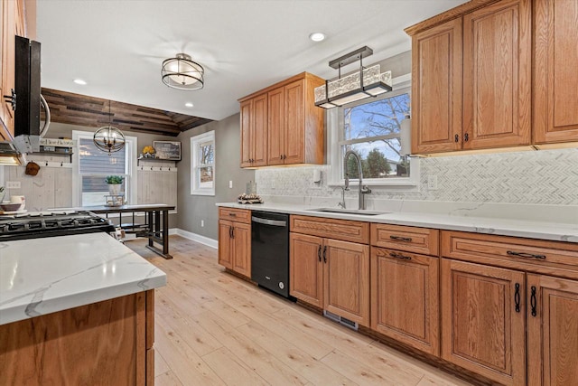 kitchen featuring pendant lighting, sink, black dishwasher, backsplash, and light hardwood / wood-style flooring