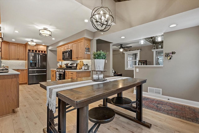 dining space featuring ceiling fan and light wood-type flooring