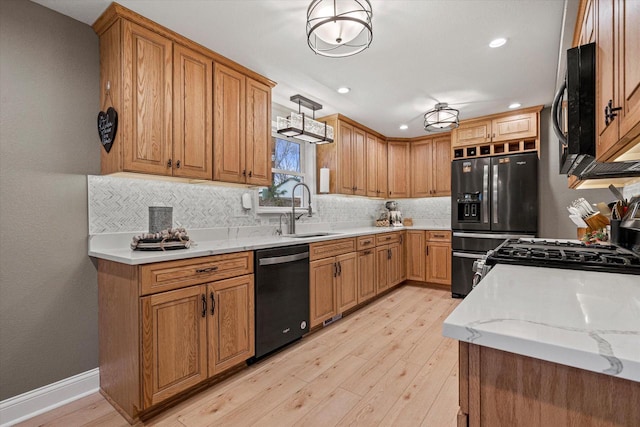 kitchen with pendant lighting, sink, light hardwood / wood-style flooring, backsplash, and black appliances