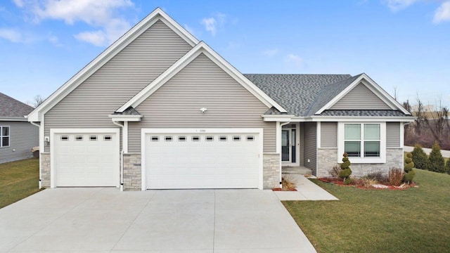 craftsman house with a garage and a front lawn