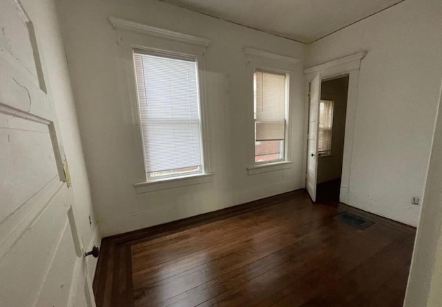 unfurnished room featuring dark wood-type flooring