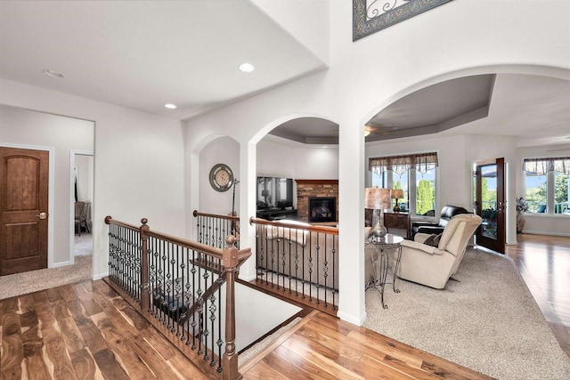 hallway featuring hardwood / wood-style floors, a tray ceiling, and plenty of natural light