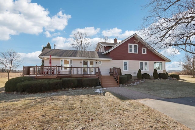 view of front of house with a deck and a front yard