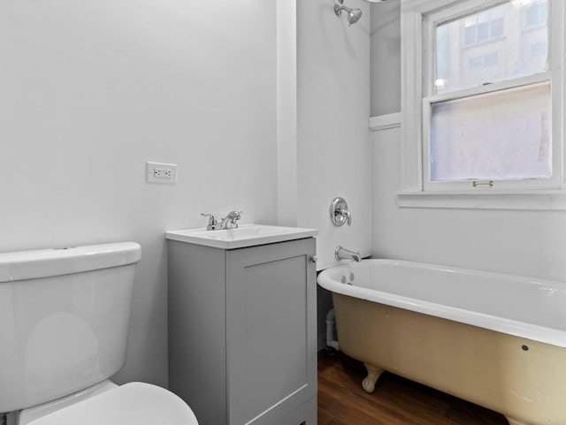 bathroom featuring hardwood / wood-style flooring, vanity, toilet, and a bathing tub