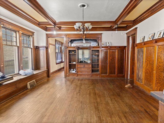 interior space featuring coffered ceiling, crown molding, a chandelier, beamed ceiling, and hardwood / wood-style floors