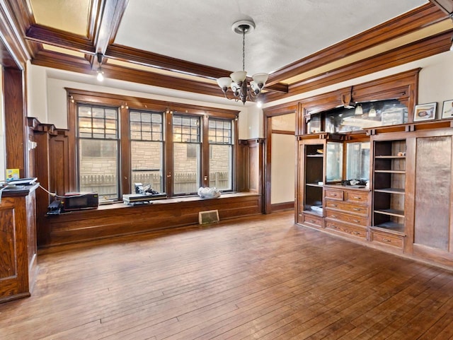 interior space with coffered ceiling, an inviting chandelier, ornamental molding, beamed ceiling, and hardwood / wood-style floors