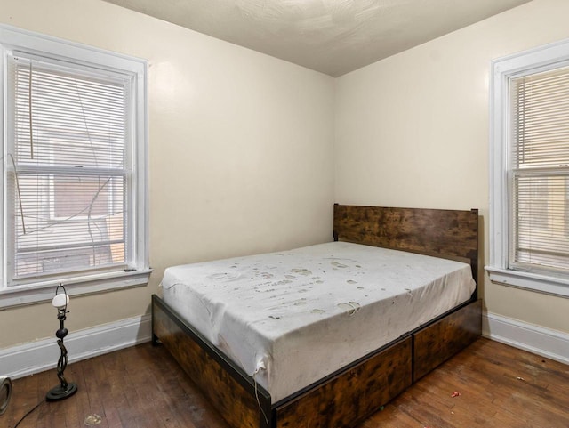 bedroom with dark hardwood / wood-style floors