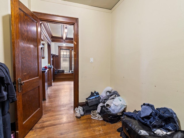 corridor featuring wood-type flooring and ornamental molding