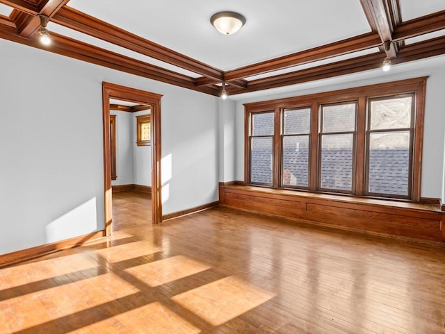 spare room featuring coffered ceiling, crown molding, light hardwood / wood-style flooring, and beamed ceiling