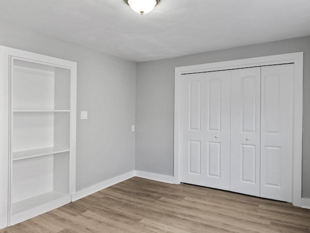 unfurnished bedroom with wood-type flooring and a closet