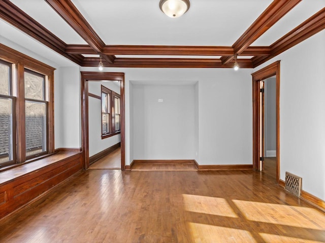 spare room with coffered ceiling, beam ceiling, and light hardwood / wood-style floors