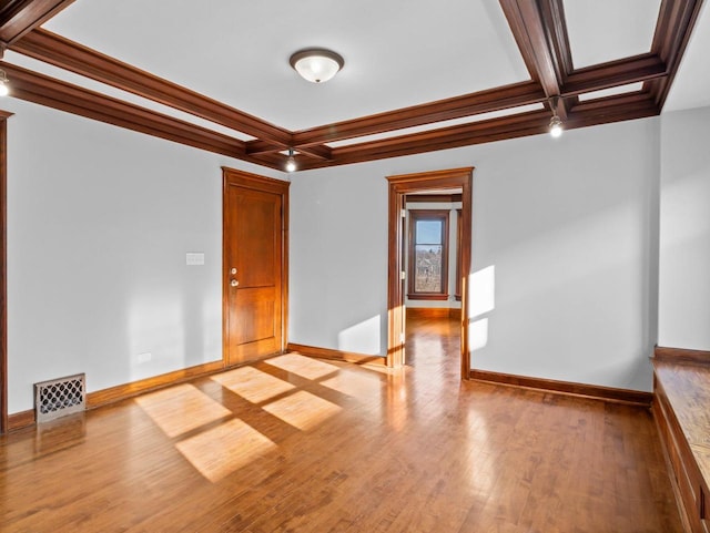 spare room featuring ornamental molding, coffered ceiling, beam ceiling, and light hardwood / wood-style flooring