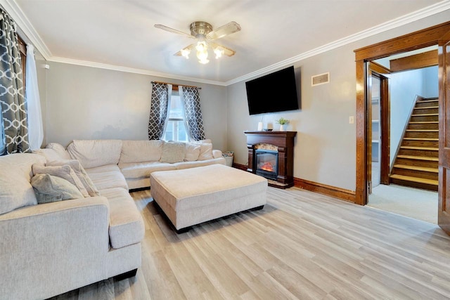 living room with crown molding, ceiling fan, and light wood-type flooring