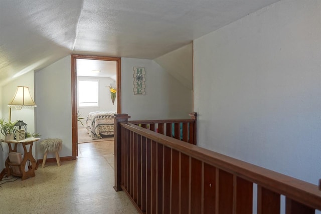 hallway featuring lofted ceiling and a textured ceiling