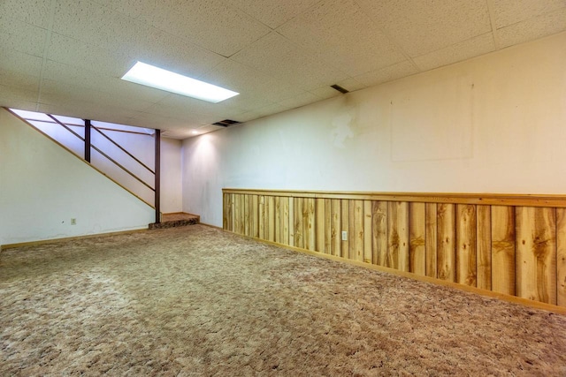 basement with carpet flooring and a paneled ceiling