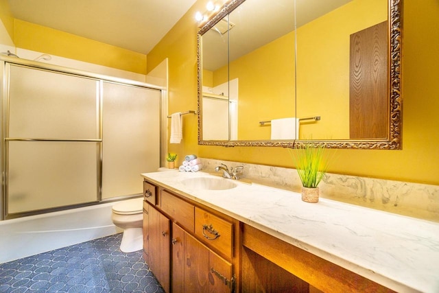 full bathroom with vanity, enclosed tub / shower combo, and toilet