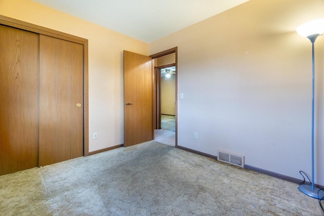 unfurnished bedroom with light carpet and a closet