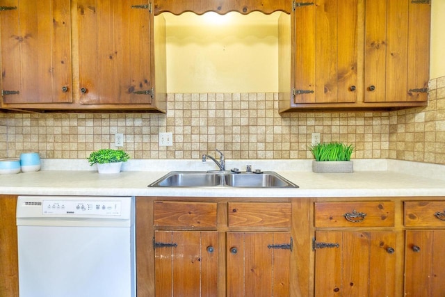 kitchen featuring tasteful backsplash, white dishwasher, and sink