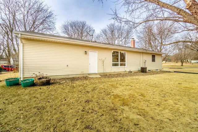 back of house with cooling unit and a yard