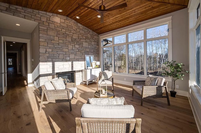 sunroom / solarium with lofted ceiling, a fireplace, wooden ceiling, and ceiling fan