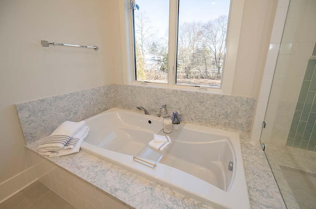 bathroom with a relaxing tiled tub