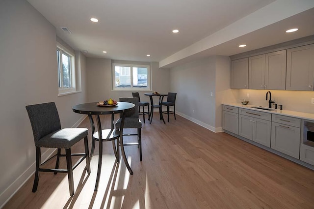 dining area with light hardwood / wood-style floors and sink