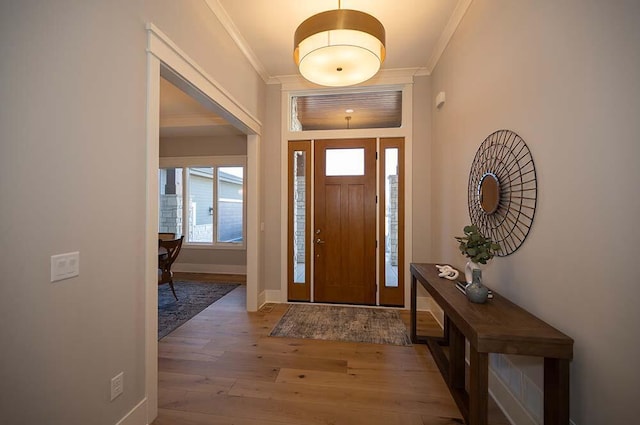 foyer entrance featuring crown molding and hardwood / wood-style flooring