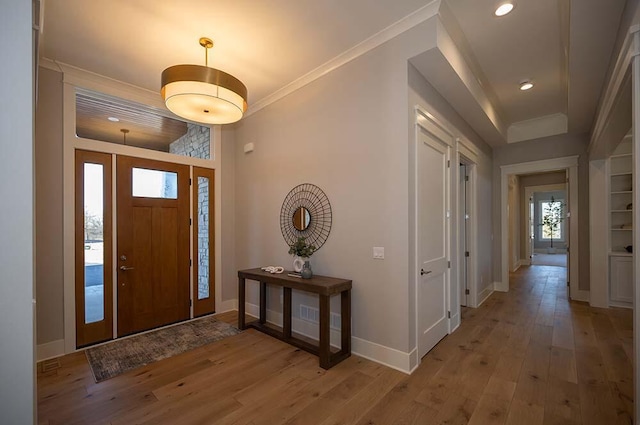 entryway featuring ornamental molding and light wood-type flooring