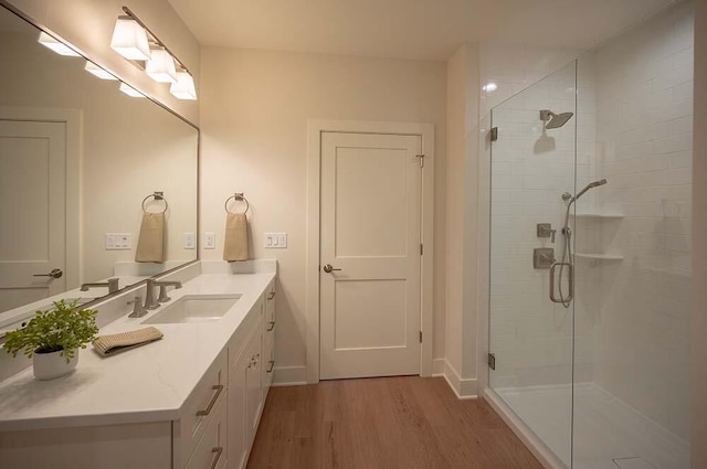 bathroom with hardwood / wood-style flooring, vanity, and a shower with shower door