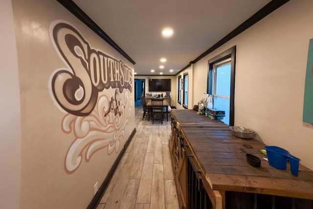 hallway featuring crown molding and light hardwood / wood-style floors