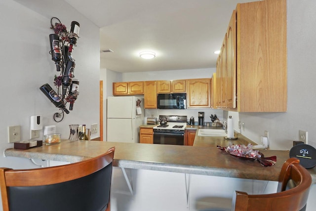 kitchen featuring sink, white fridge, and stove