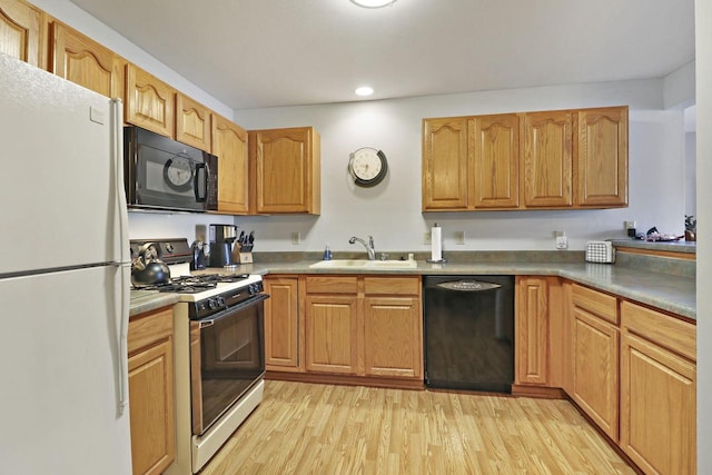 kitchen with sink, black appliances, and light hardwood / wood-style floors