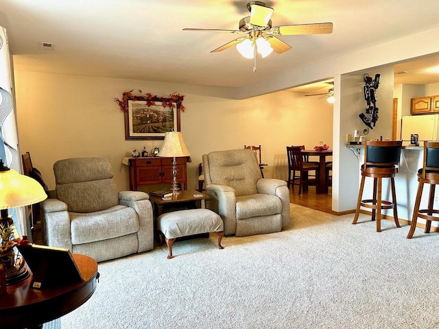 carpeted living room featuring ceiling fan