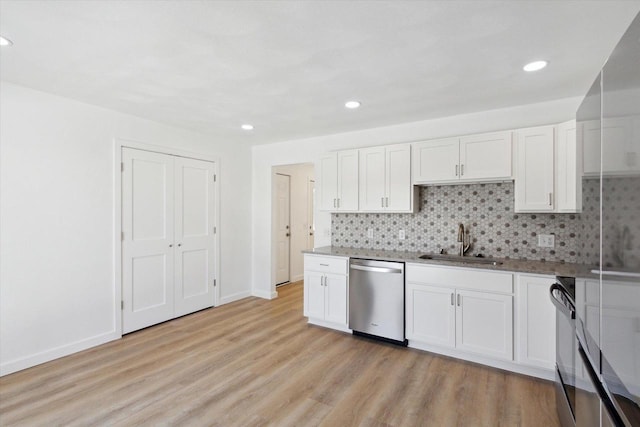 kitchen with white cabinetry, sink, stainless steel dishwasher, and decorative backsplash