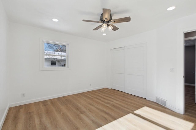 unfurnished bedroom with light hardwood / wood-style floors, a closet, and ceiling fan