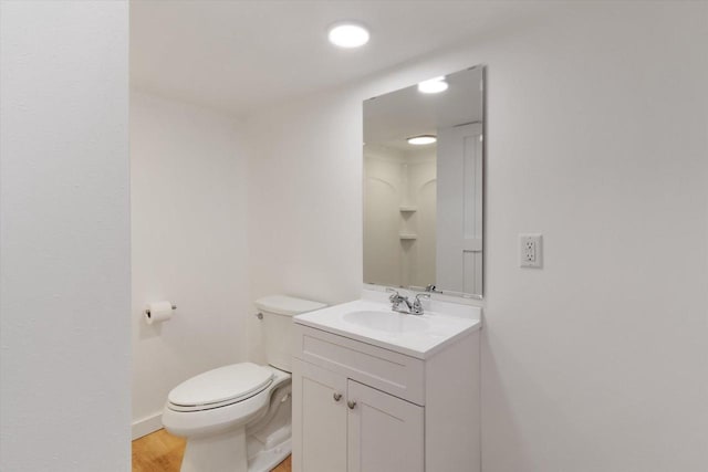 bathroom with hardwood / wood-style flooring, vanity, and toilet