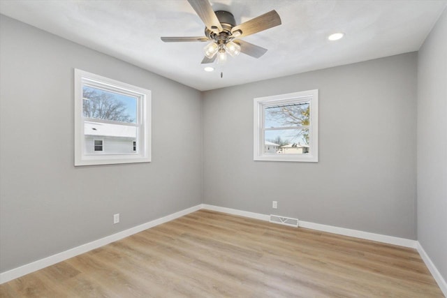 empty room with ceiling fan and light hardwood / wood-style flooring