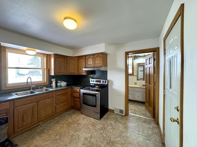 kitchen featuring electric stove, sink, and backsplash