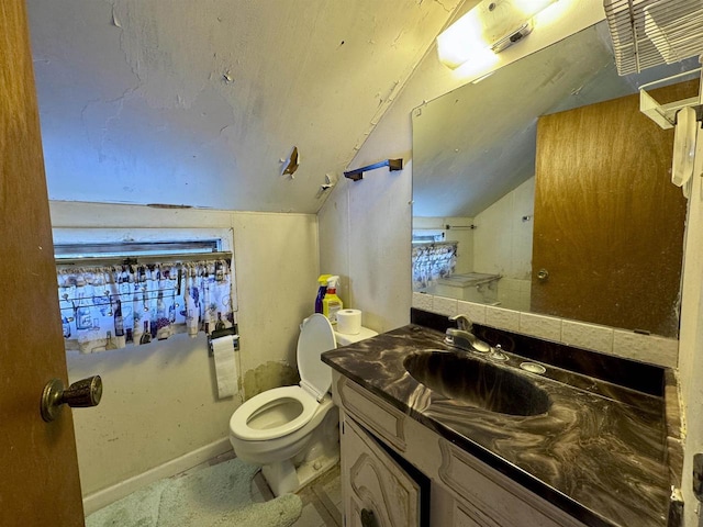 bathroom with vanity, lofted ceiling, and toilet