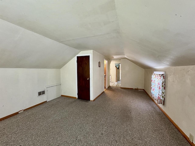 bonus room with vaulted ceiling and carpet flooring