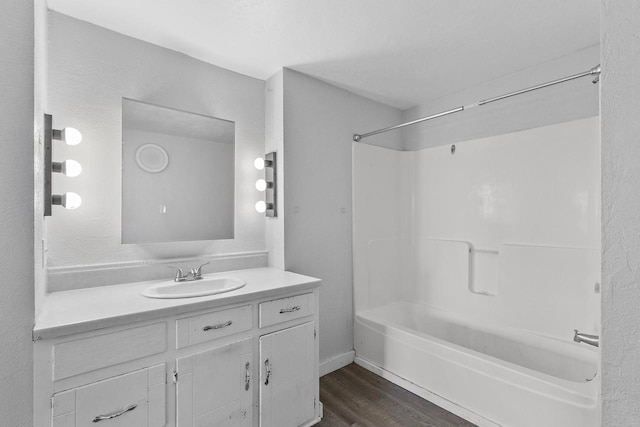 bathroom featuring shower / washtub combination, hardwood / wood-style floors, and vanity