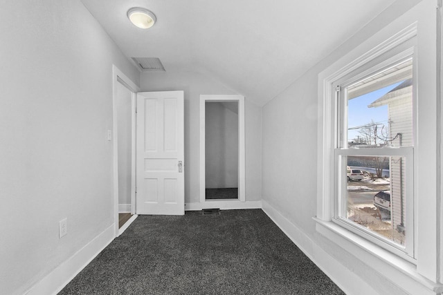 bonus room with vaulted ceiling and dark colored carpet